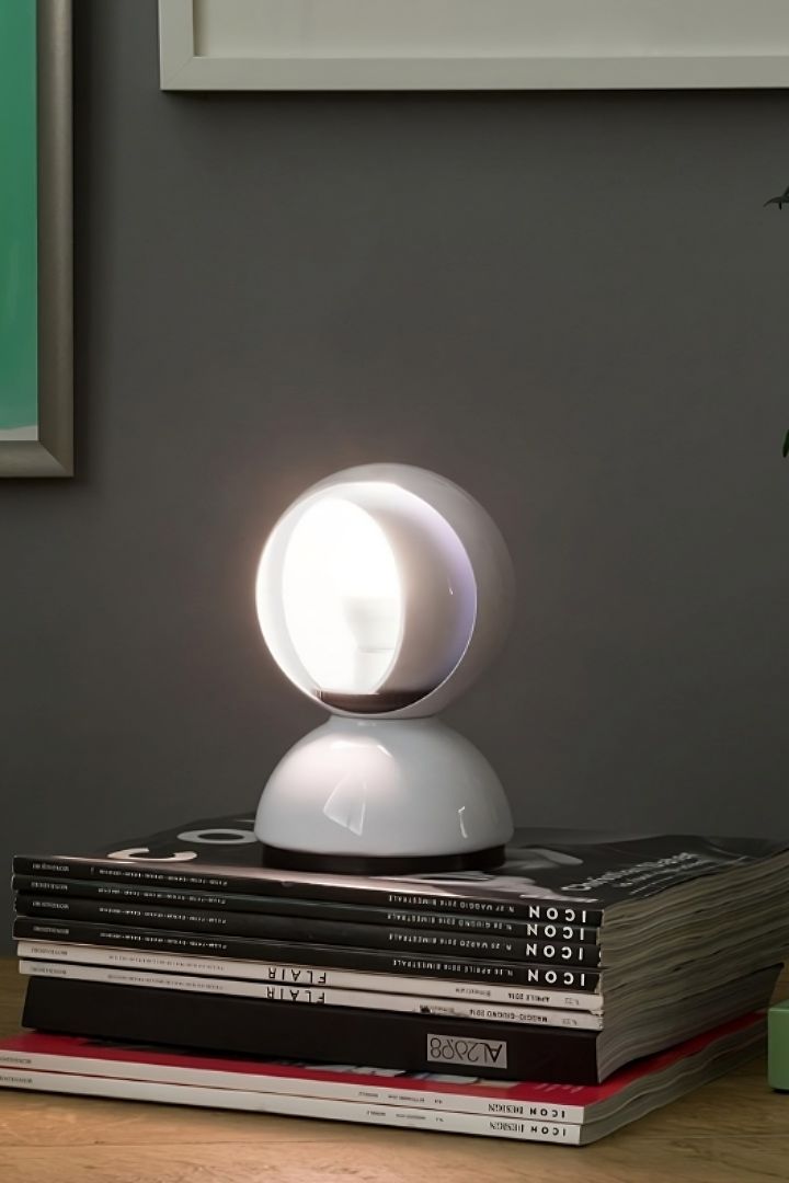 La lampe Eclisse d'Artemide repose sur une pile de livres. 