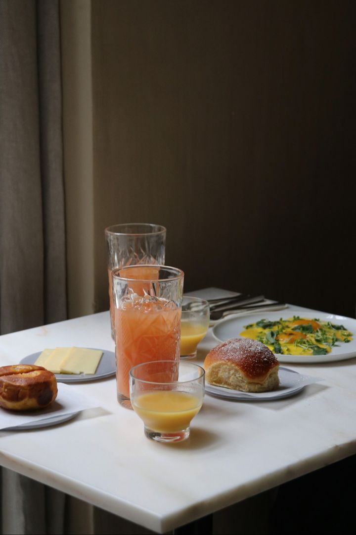 Une table garnie de nourriture et de boissons au restaurant Audo à Copenhague. C'est l'endroit idéal pour manger un morceau à l'heure du déjeuner pour tout amateur de design qui visite Copenhague. 