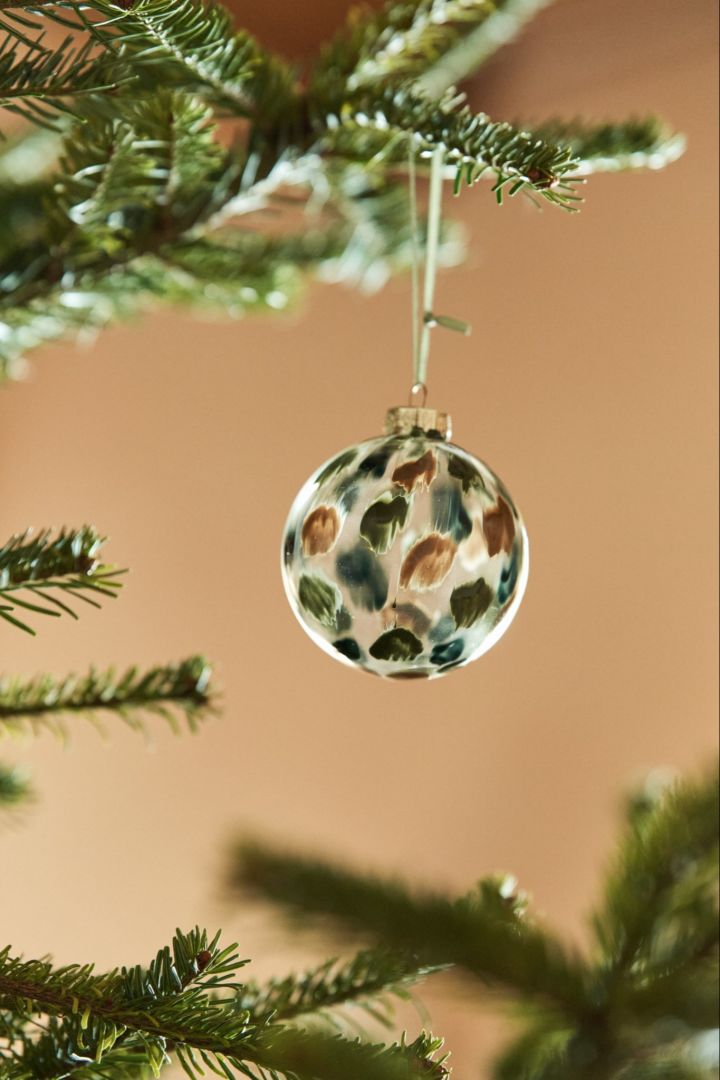 Découvrez des idées de décoration de sapin de Noël sur le thème de la nature, comme la boule Overcast dans les tons verts et bruns de Scandi Living. v