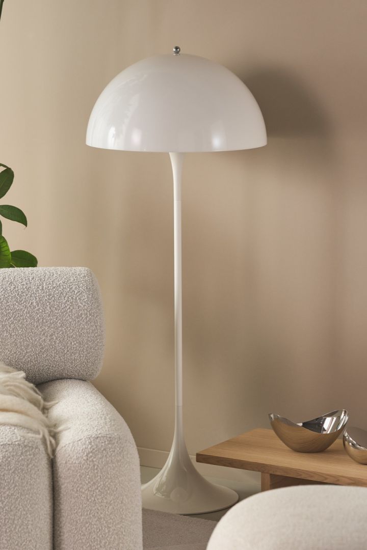 Renouvelez votre intérieur avec des lampadaires modernes - ici vous voyez le lampadaire Pathella dans un salon beige avec des plantes vertes et des meubles épais. 