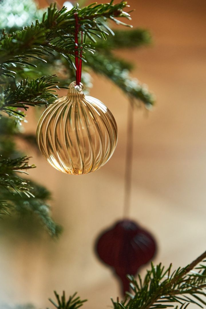 Les boules de verre sont de parfaites idées de décoration pour le sapin de Noël. Ici, vous voyez les boules de verre dorées Holiday de Scandi Living.