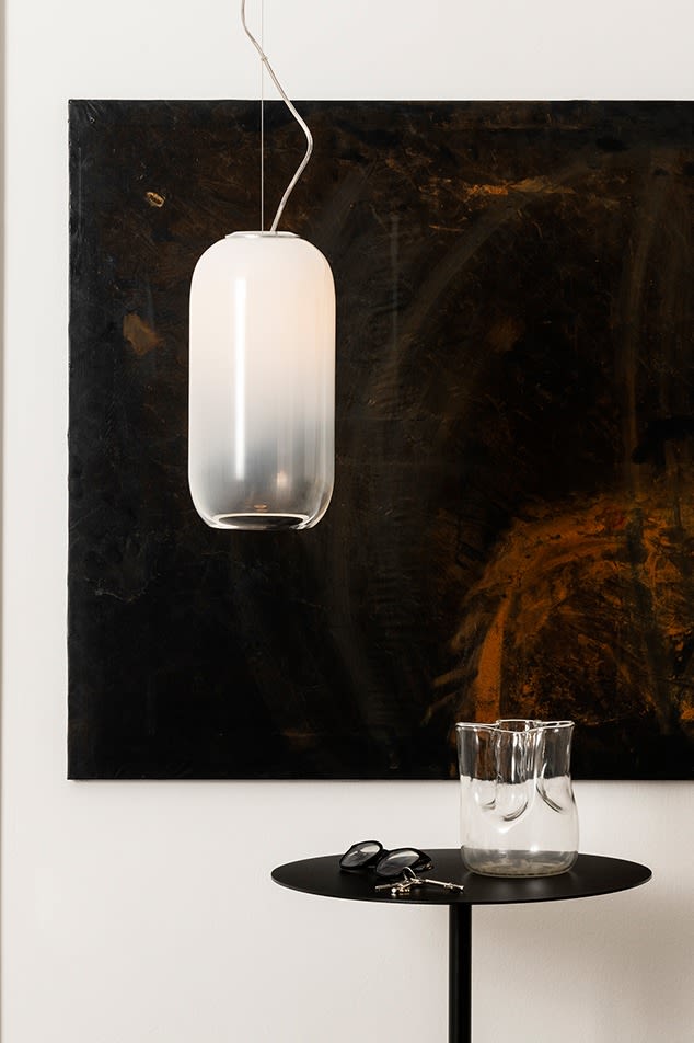 La lampe suspendue Gople est suspendue au-dessus d'une table d'appoint avec un vase en verre transparent. 