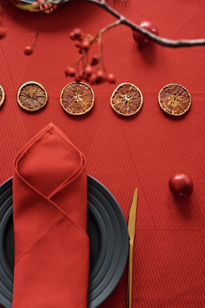 Table rouge pour Noël avec serviette et nappe en lin rouge ainsi que des assiettes grises de NJRD.