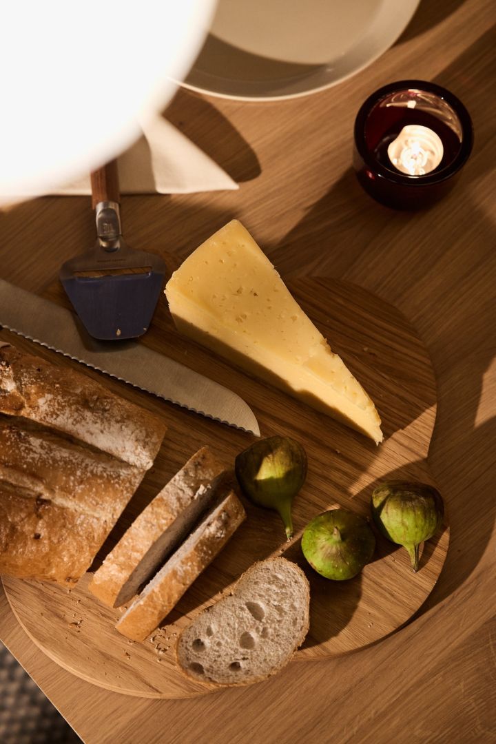 Du pain croustillant, des figues et du fromage sont disposés sur le plateau en bois Alvar Aalto de Iittala dans le cadre d'une célébration nordique de Noël. 