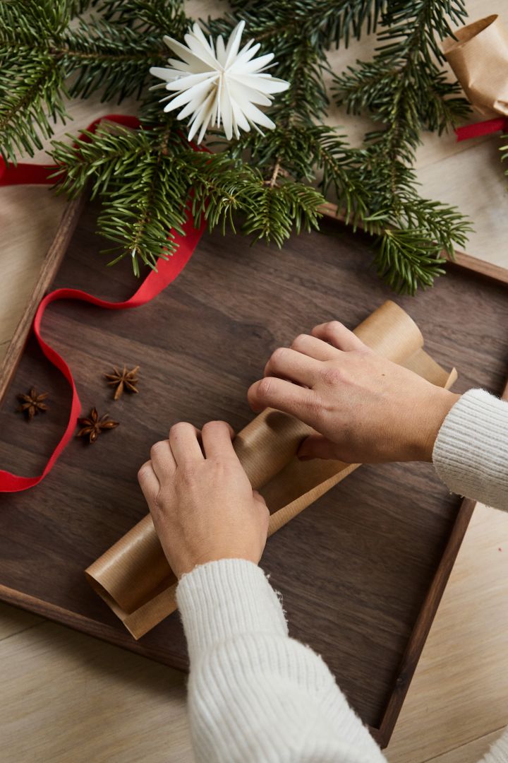 Deuxième étape de la fabrication de votre propre cracker de Noël : enroulez le papier autour du rouleau de papier hygiénique. 