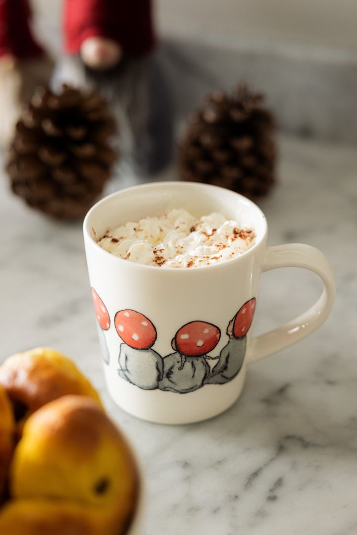 Une tasse de chocolat chaud, que l'on voit ici dans l'adorable tasse Children of the forest de Design House Stockholm à côté d'un bol de Lussekatter, est un élément important de la fête de Noël suédoise, ainsi que des histoires de Noël suédoises.