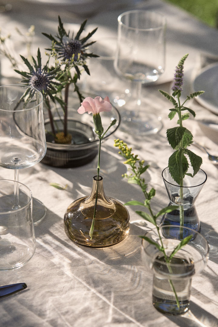 Différents vases mini-Midsummer de Orrefors sur une table au soleil.