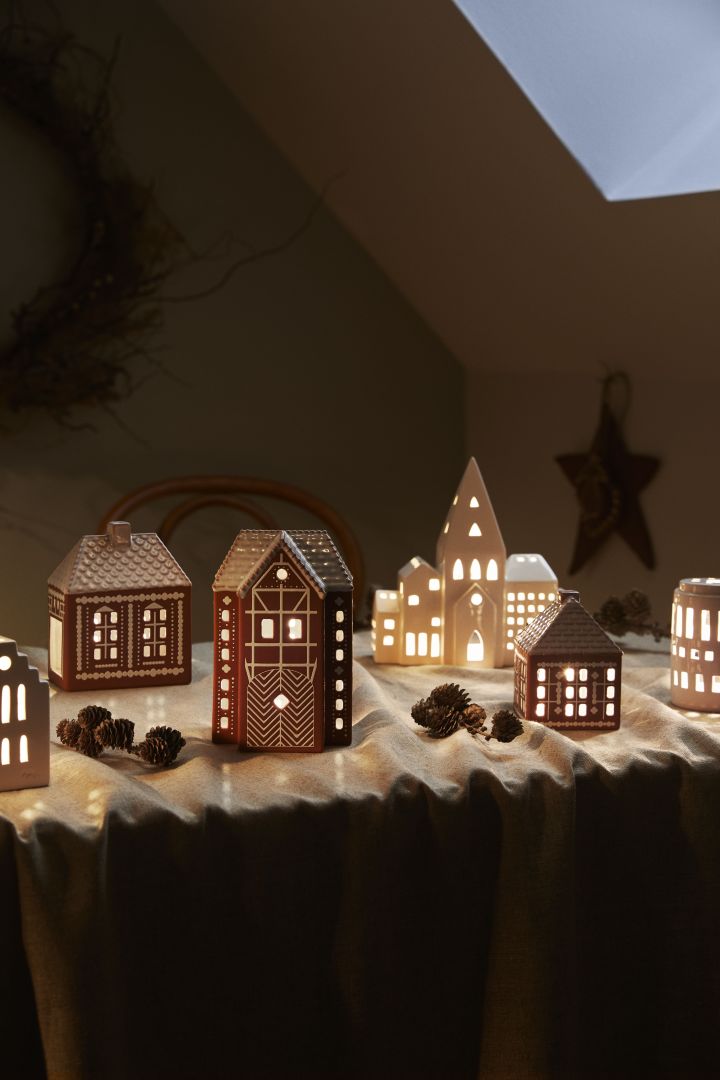 Décorez avec des décorations de Noël scandinaves traditionnelles et créez un village de pain d'épices sur le rebord de la fenêtre avec les photophores de Kähler. 