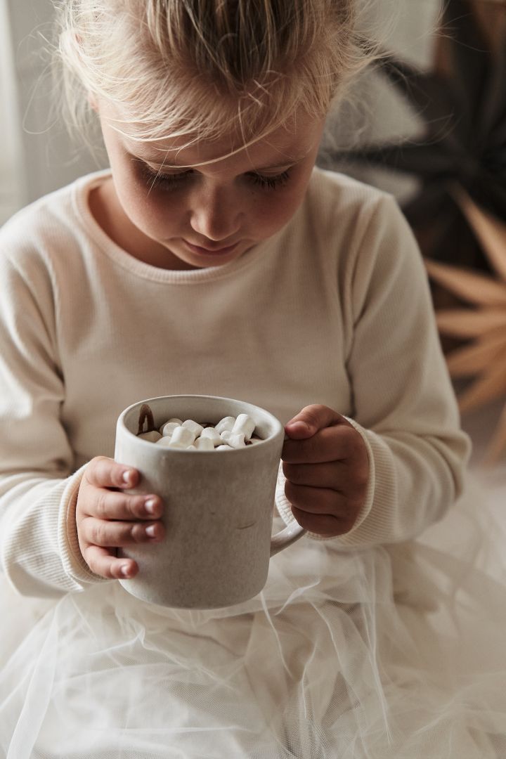 Les objets de style de vie scandinave que vous devez essayer cet hiver - faire du chocolat chaud avec les enfants - ici vous voyez une fille avec la tasse sandsbro de Scandi Living. 