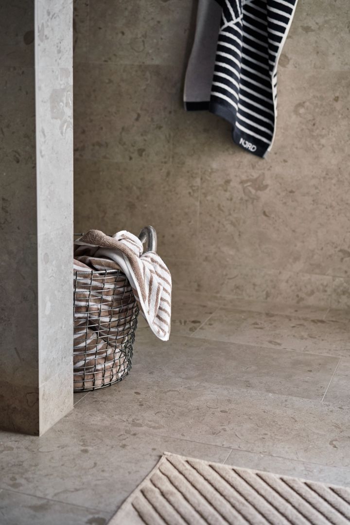 Des idées de décoration pour la salle de bain, dont ce panier Korbo, des serviettes NJRD et un tapis de bain. 