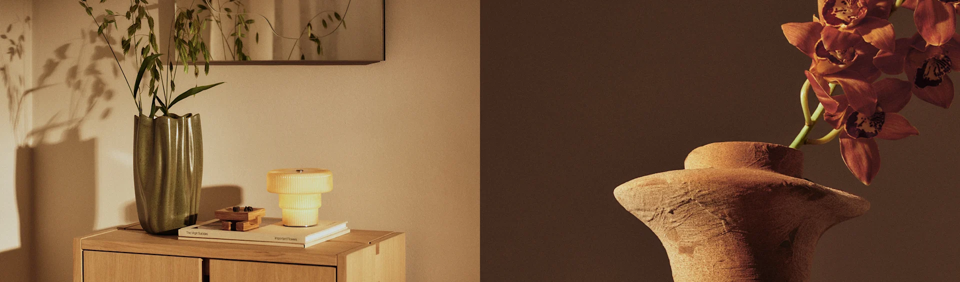 Deux vases présentent des plantes, un vase vert avec du feuillage sur une commode à côté d'une lampe jaune, et un vase en terre cuite avec des orchidées oranges.