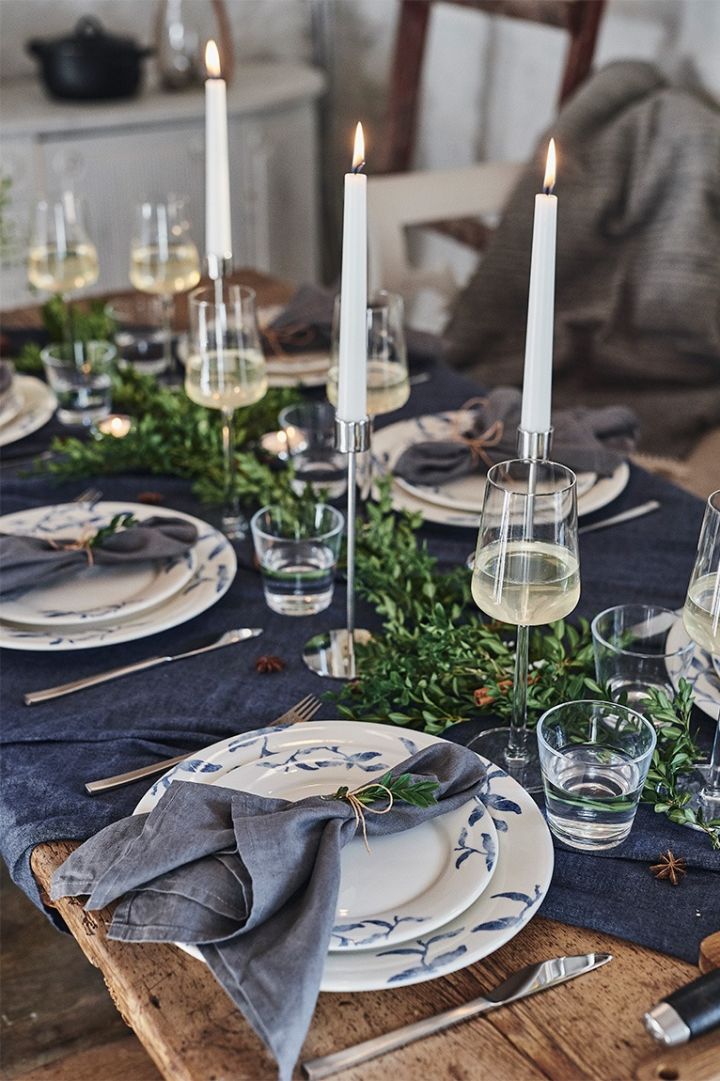 Table de Noël dressée de manière romantique en bleu avec de la porcelaine bleue et blanche de Scandi Living et des chandeliers de Cooee Design.