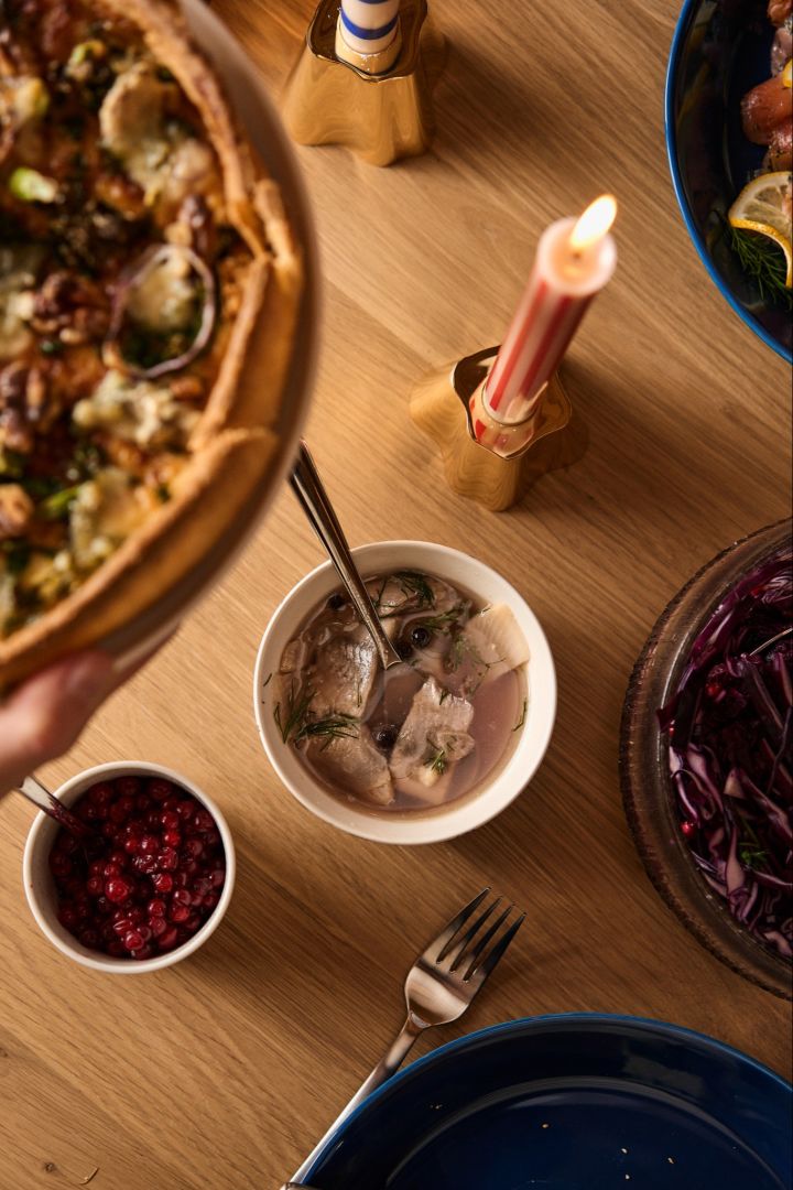 Un pot de baies de ligon suédoises traditionnelles et de harengs marinés sur une table de Noël nordique.