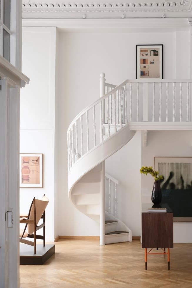 Voici la salle d'exposition de la Maison Finn Juhl, d'un blanc éclatant et d'une grande élégance, avec son escalier en colimaçon. La Maison Finn Juhl est une visite incontournable pour tout amateur de design lors d'une visite de Copenhague. 