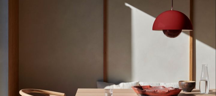 Des idées d'éclairage modernes pour mettre la touche finale à votre maison. Ici, la lampe suspendue VP1 de &Tradtion, d'un rouge profond, est suspendue au-dessus d'une table à manger. 