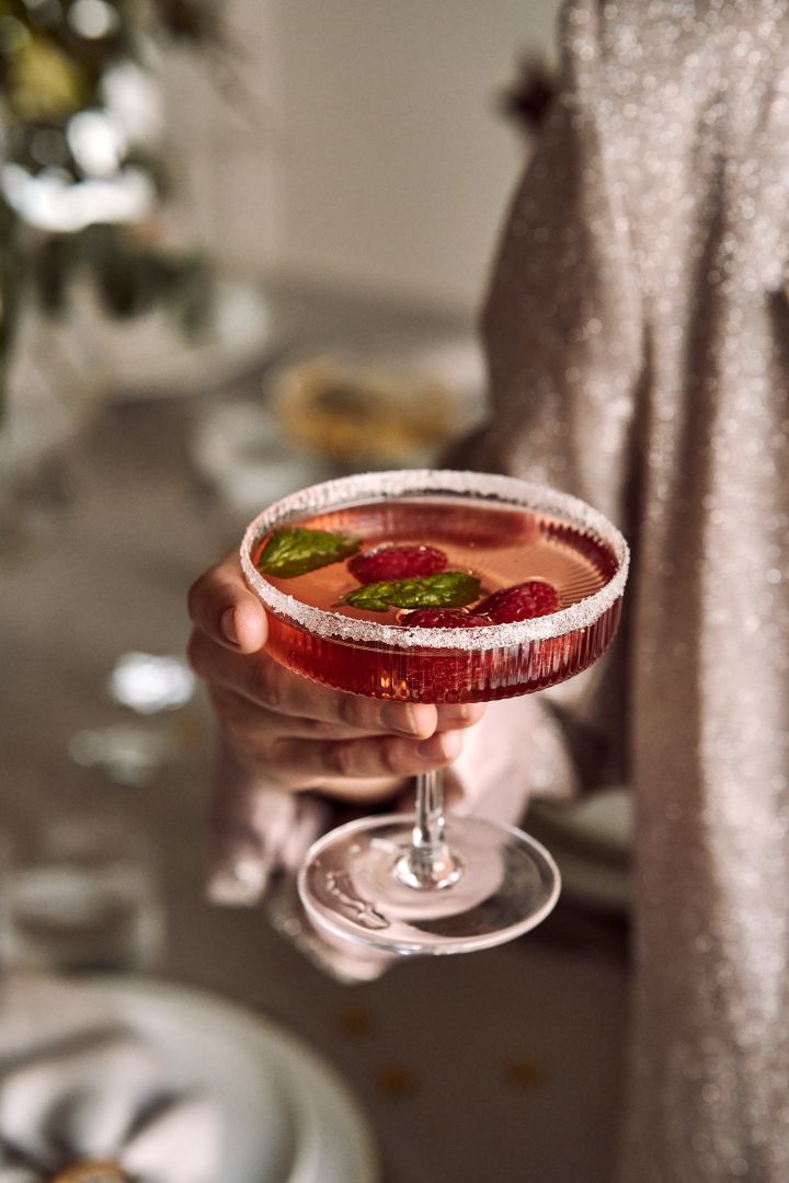 Essayez ces cocktails festifs pour votre fête de fin d'année. Voici un cocktail à base de framboise et de champagne dans un verre à cocktail ondulé. 