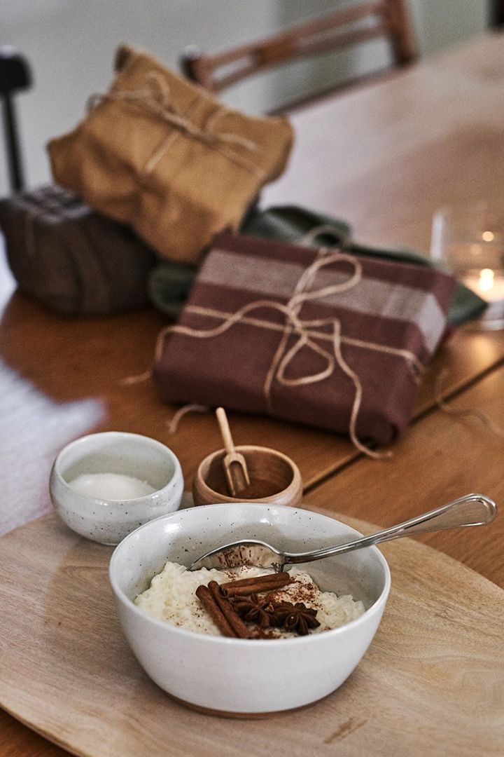 Un riz au lait de Noël est servi sur la table dans un bol rustique.