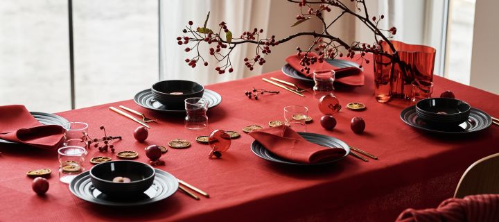 Service de table avec porcelaine Lines gris foncé de NJRD, serviettes de table en lin rouge et nappe en lin rouge de NJRD pour une table de Noël festive.