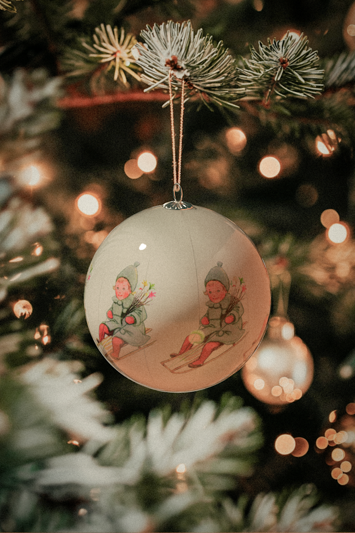 La décoration du sapin de Noël est également un élément essentiel de la fête de Noël suédoise, ainsi que de notre histoire de Noël suédoise. Ici, vous voyez l'une des boules de Noël avec des motifs d'Elsa Beskow de Design House Stockholm.