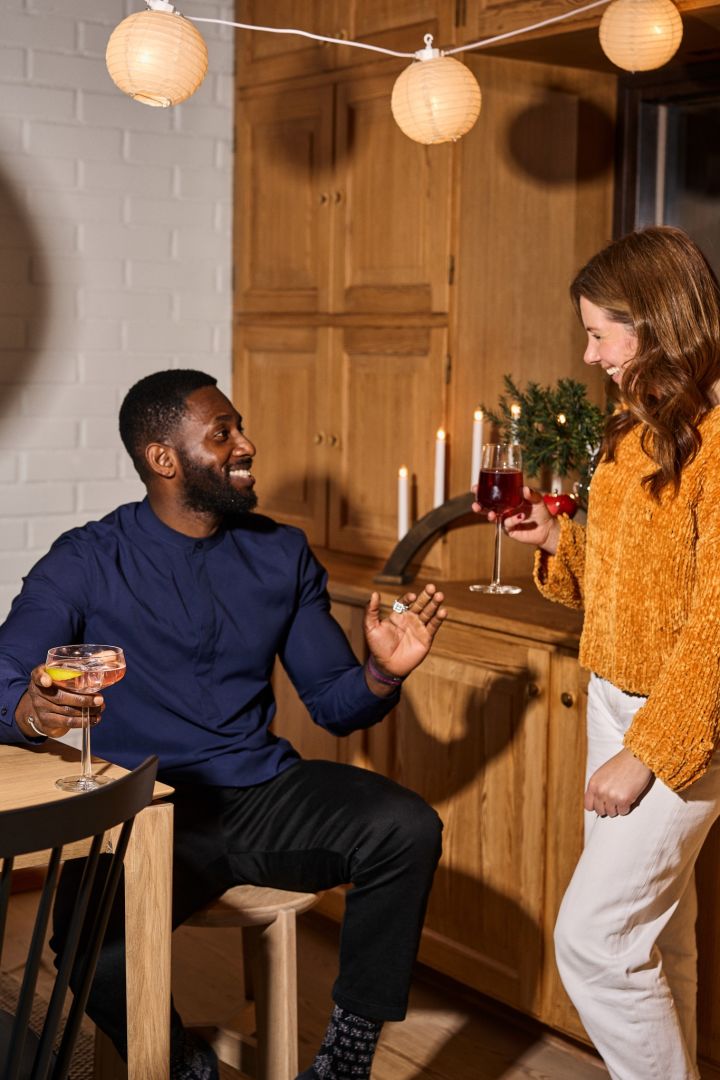 Des amis rient ensemble autour d'un verre lors d'une fête de Noël nordique traditionnelle. 