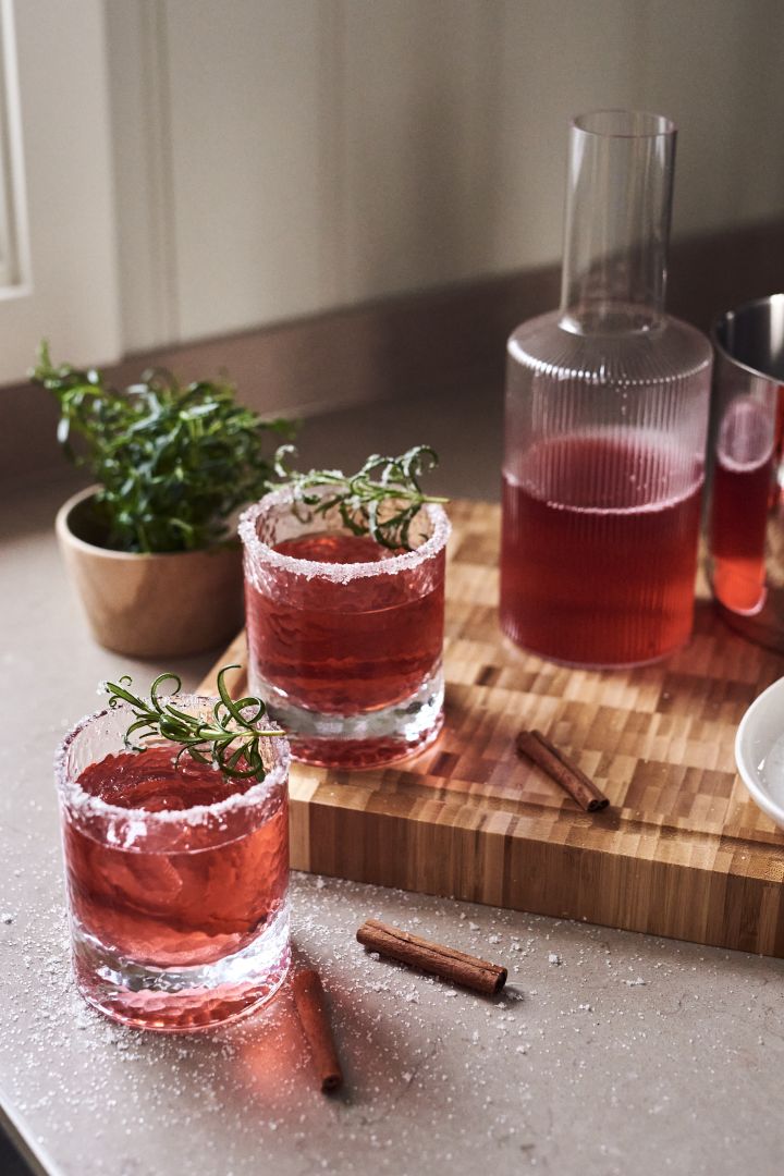 4 recettes de cocktails festifs pour le nouvel an - Verre à eau Holmegaard Forma à côté de la carafe Ferm Living Ripple.